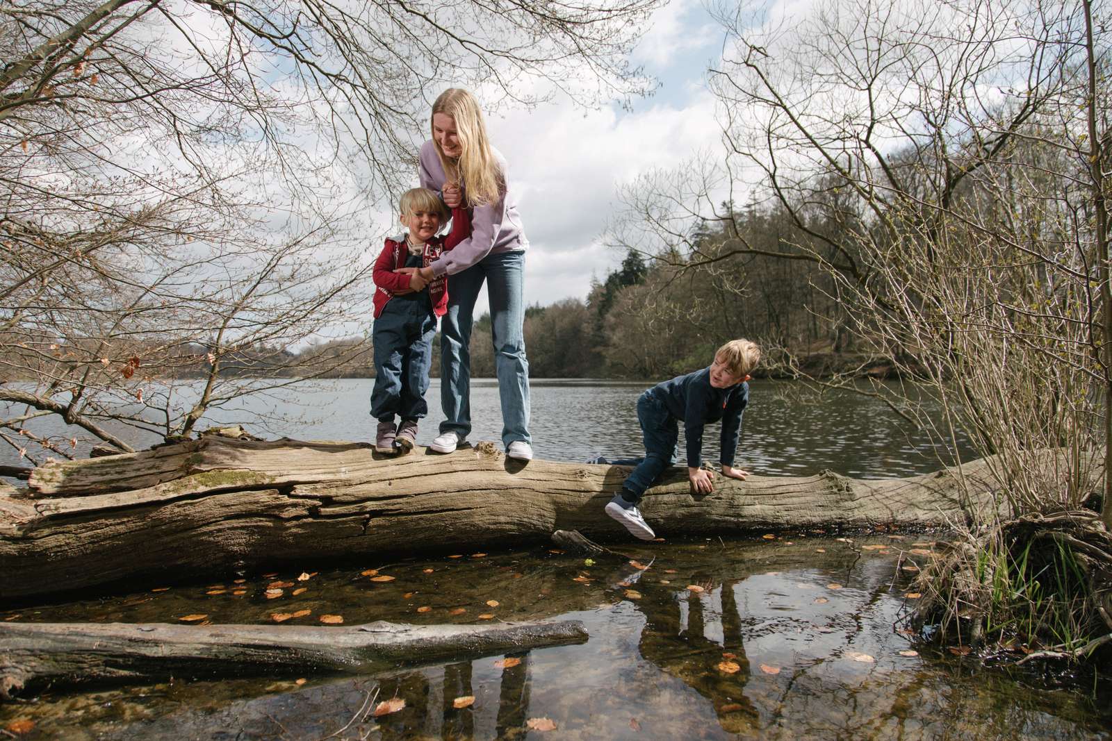 Børn klatrer på træstamme i vandet ved Langesø